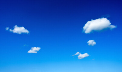 Fluffy clouds on the blue sky as a background