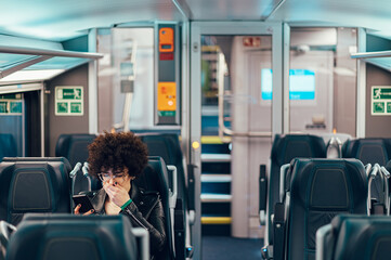 Woman tourist traveling by the train and using smartphone