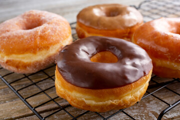 A view of several donuts on a cooling rack.