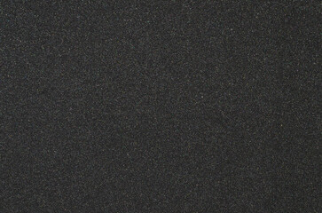 dark black spongy foam material surface texture background porous and fine grain