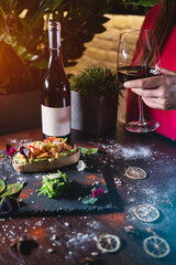 person eats fresh sandwich with avocado, red salmon fried fish, seaweed, wine