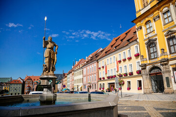 Fototapeta na wymiar Cheb, Western Bohemia, Czech Republic, 14 August 2021: King George of Podebrady Square, Eger at sunny day, medieval colorful historic renaissance and baroque buildings, Fountain with statue of Roland