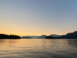 Obraz premium Sunset scene over mountains with reflection on water, near Thetis Island, Vancouver Island, British Columbia, Canada