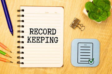 Record keeping text written on a notebook with pencils