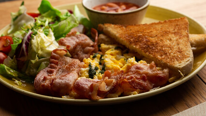 Poached eggs with vegetable, ham, tomatoes, red beans and sourdough toast isolated on wood background. Homemade food. Tasty breakfast.