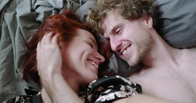 Young married couple laughing and takes a selfie after waking up in morning