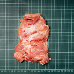 Raw skinless boneless chicken thigh, for cooking.Chicken thigh,leg meat on a line board.