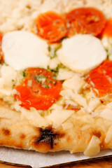 Premium high quality pizza with mozzarella cheese and tomato. Italian style dish with top products. Close up.