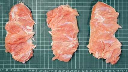 Raw skinless boneless chicken thigh, for cooking.Chicken thigh,leg meat on a line board.