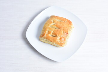 Puff pastry cheese cake, accompanied by corn sauce on a wooden background