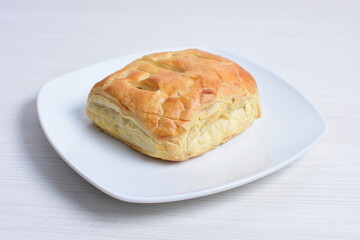 Puff pastry cheese cake, accompanied by corn sauce on a wooden background