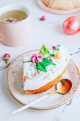 Slice of Easter kulich cake on a plate over white marble table