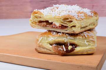Puff pastry cake with arequipe and cheese, grated coconut on wooden background