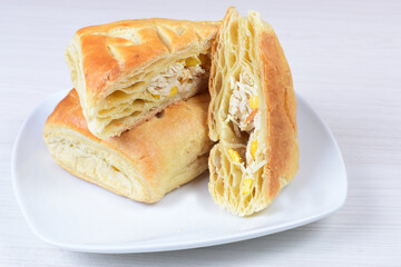Chicken and cheese puff pastry, accompanied by corn sauce on a wooden background