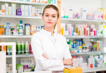 Portrait of young smiling cheerful positive female pharmacist in modern drugstore
