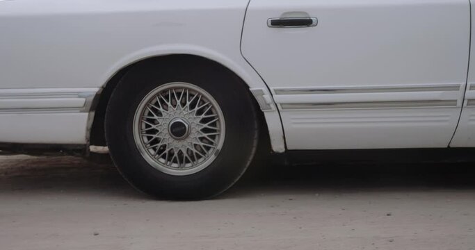 Retro car pulls up and a young woman gets out of it