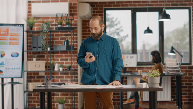 Nervous man checking time on watch and waiting important call to discuss business strategy and project planning. Employee preparing for remote conversation with manager about presentation