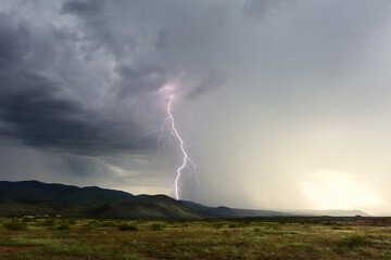 Naklejka na ściany i meble Thunderstorm and lightning strike hitting a mountain
