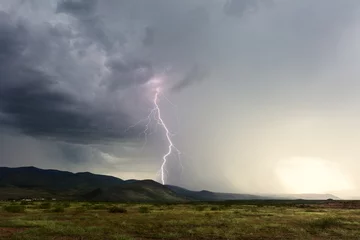 Fotobehang Thunderstorm and lightning strike hitting a mountain © JSirlin