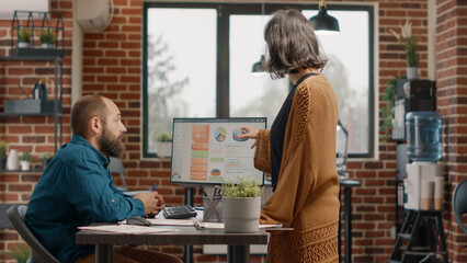 Business people doing teamwork on project planning, designing rate charts on computer in startup office. Man and woman working together to plan data analysis and presentation on monitor