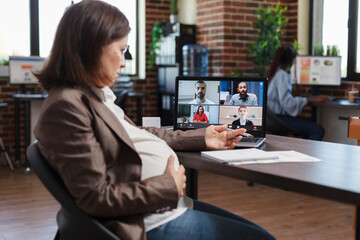 Pregnant woman on virtual conference videocall communicating marketing strategy to company...