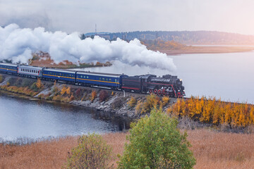 Fototapeta na wymiar Retro steam train moves along the lake.