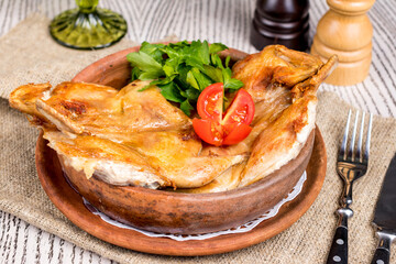 Quail on the grill on brown bowl on wooden table