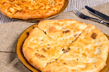 Kubdari with meat on old wooden table and side khachapuri, georgian cuisine