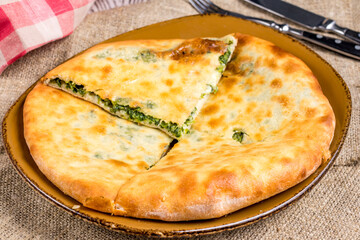 khachapuri with spinach and cheese on the board, georgian cuisine macro close up