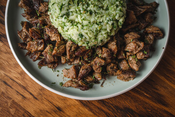 Beef and rice with spinach prepared meal in plate on the table ready to eat