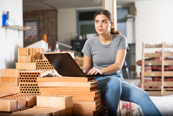 Young woman architect with laptop working on indoor building construction site, developing concept...
