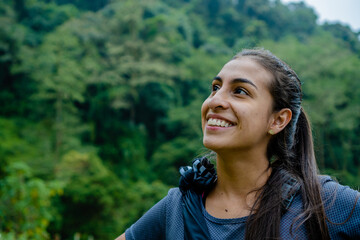 portrait of a smiling young latina woman on a jungle hike