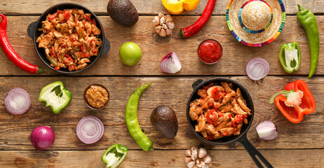 Composition with delicious Fajita, vegetables, sauce and sombrero hat on wooden background