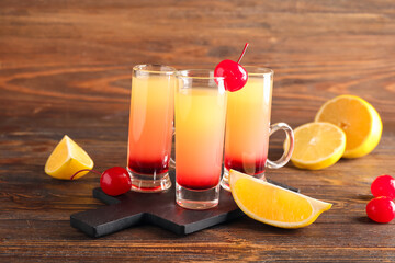 Board with tasty Pineapple Upside Down Cake Shots on wooden background