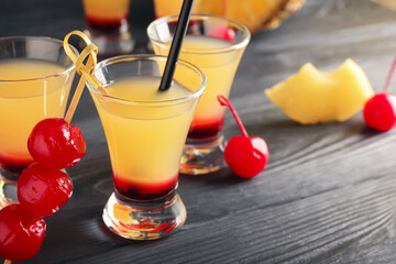 Tasty Pineapple Upside Down Cake Shots on black background, closeup