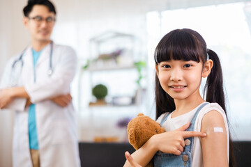 Young asian doctor wearing gloves and isolation  is making a COVID-19 vaccination in the shoulder...