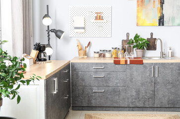 Wooden counters with silver sink and cookware in light kitchen