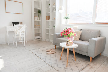 Cube calendar with date MARCH 8 and bouquet of tulips on table in room interior. International Women's Day celebration