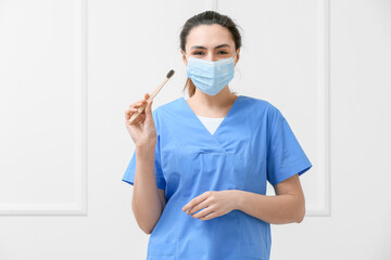 Female dentist with activated charcoal tooth paste and brush on light background