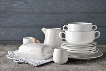 Set of stylish dinnerware on grey wooden background