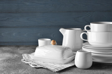 Set of stylish dinnerware on grey wooden background
