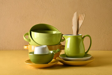 Set of stylish dinnerware on yellow background