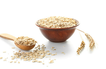 Bowl and spoon with raw oatmeal flakes on white background