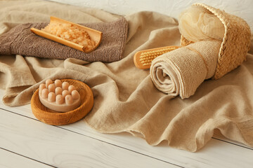 Fototapeta na wymiar Set of bath supplies with massage soap on light wooden background