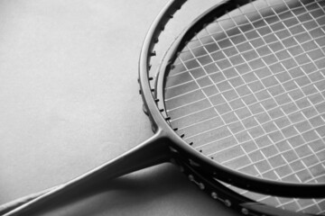 Badminton rackets on badminton indoor court floor, the upper racket is broken and has no string, soft and selective focus.