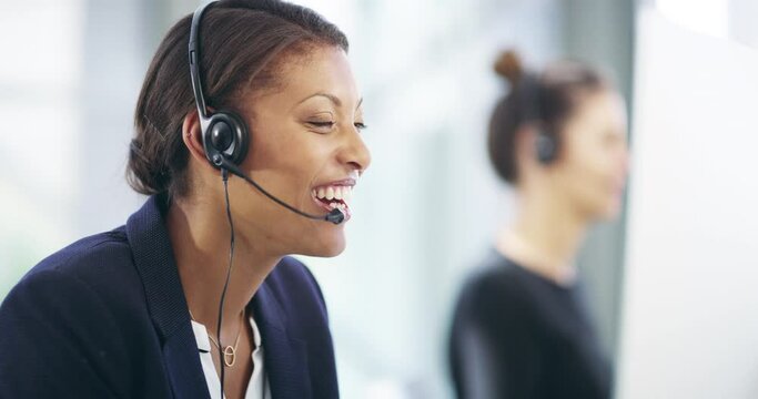 She prides herself on having a helpful attitude. 4k video footage of an attractive young female callcenter agent working on a desktop in her office with a colleague in the background.