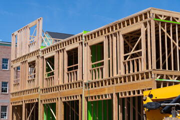Fototapeta na wymiar New residential construction home framing against a blue sky