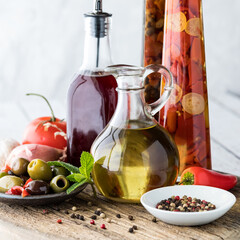 An arrangement of oil and red wine vinegar with olives and peppercorns