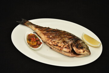 Roasted fish with lemon slices and  spicy sauce,dorada