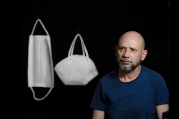 Portrait of two protective masks against covid-19 and a man counts on black background.